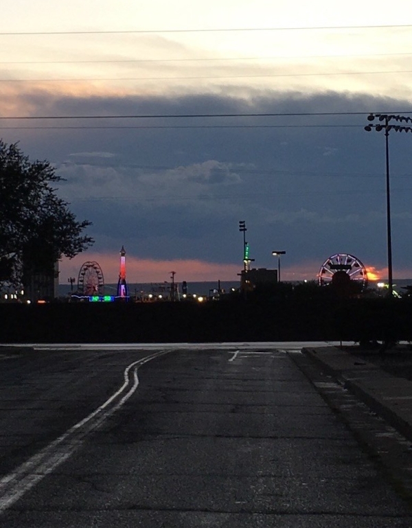 View of carnival rides from a dark street in the War Zone